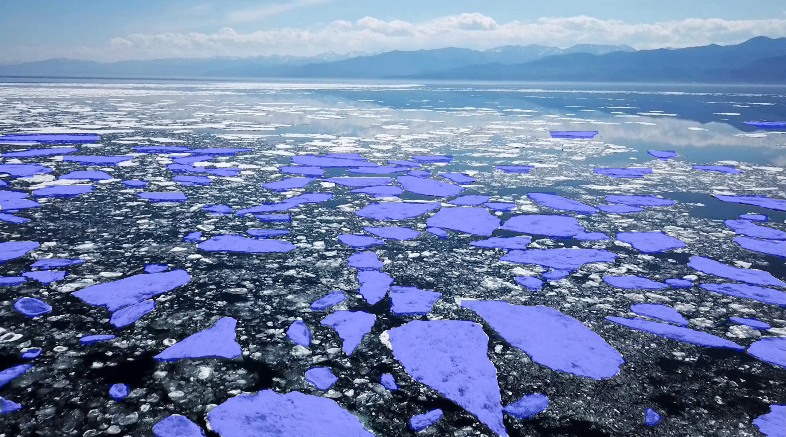 AI segmentation masks identifying ice formations on open water with mountains in background